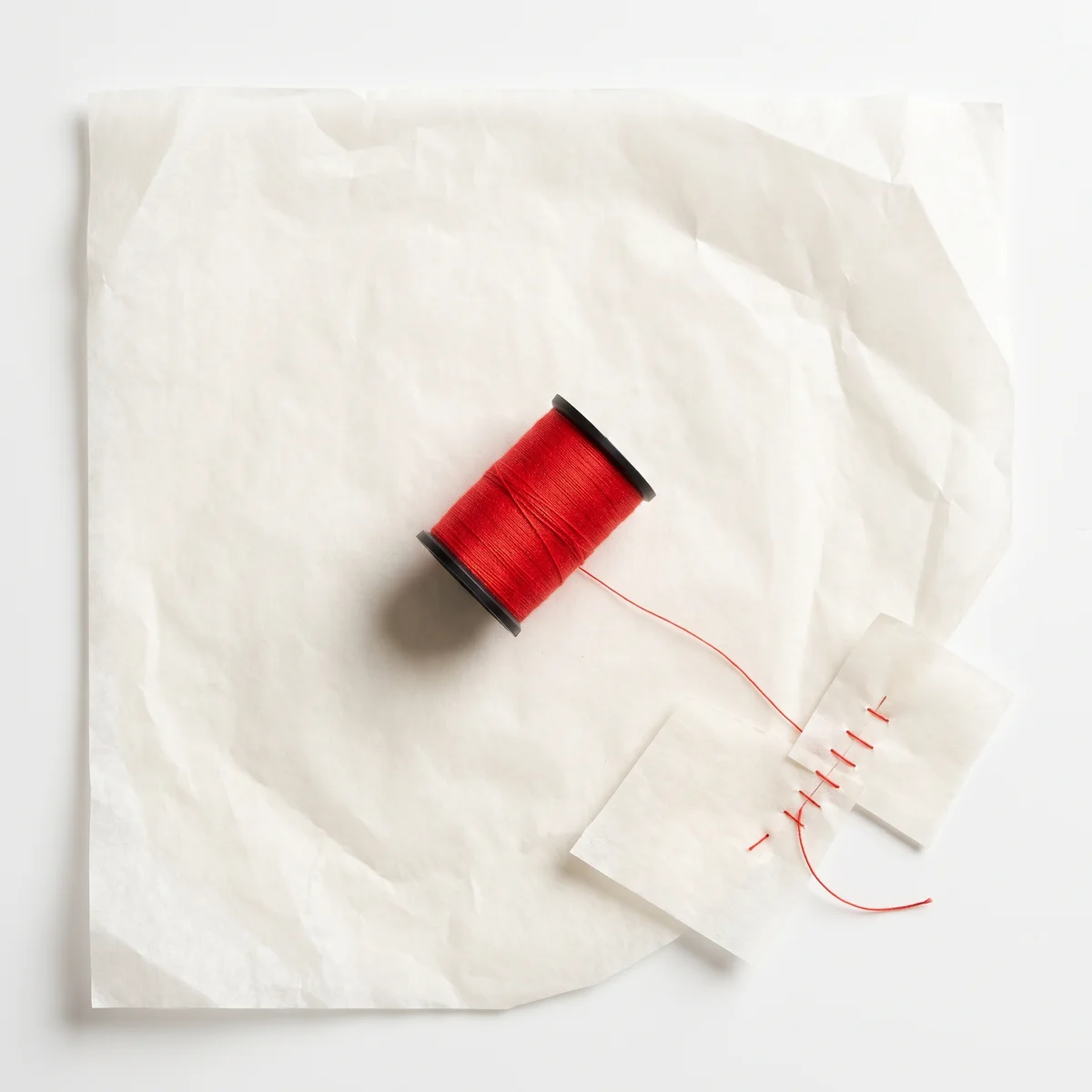 Un rocchetto di filo rosso su carta da modello